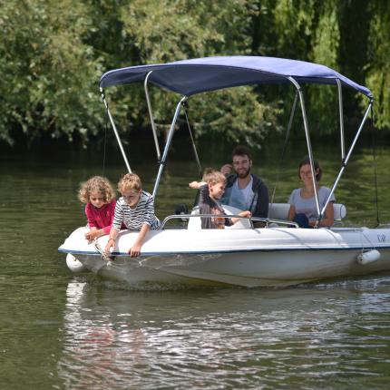 Photo d'une famille sur un bateau en croisière sur le canal de la Somme