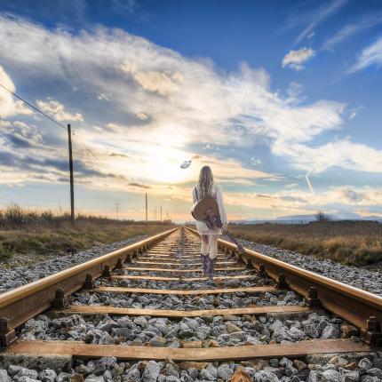 Photo d'une voyageuse marchant sur des rails