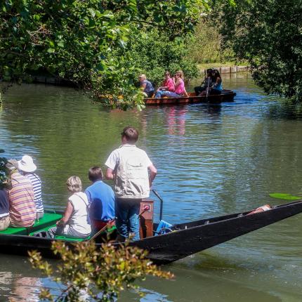 Photo d'un groupe de personnes en visite sur une barque dans les Hortillonnages d'Amiens